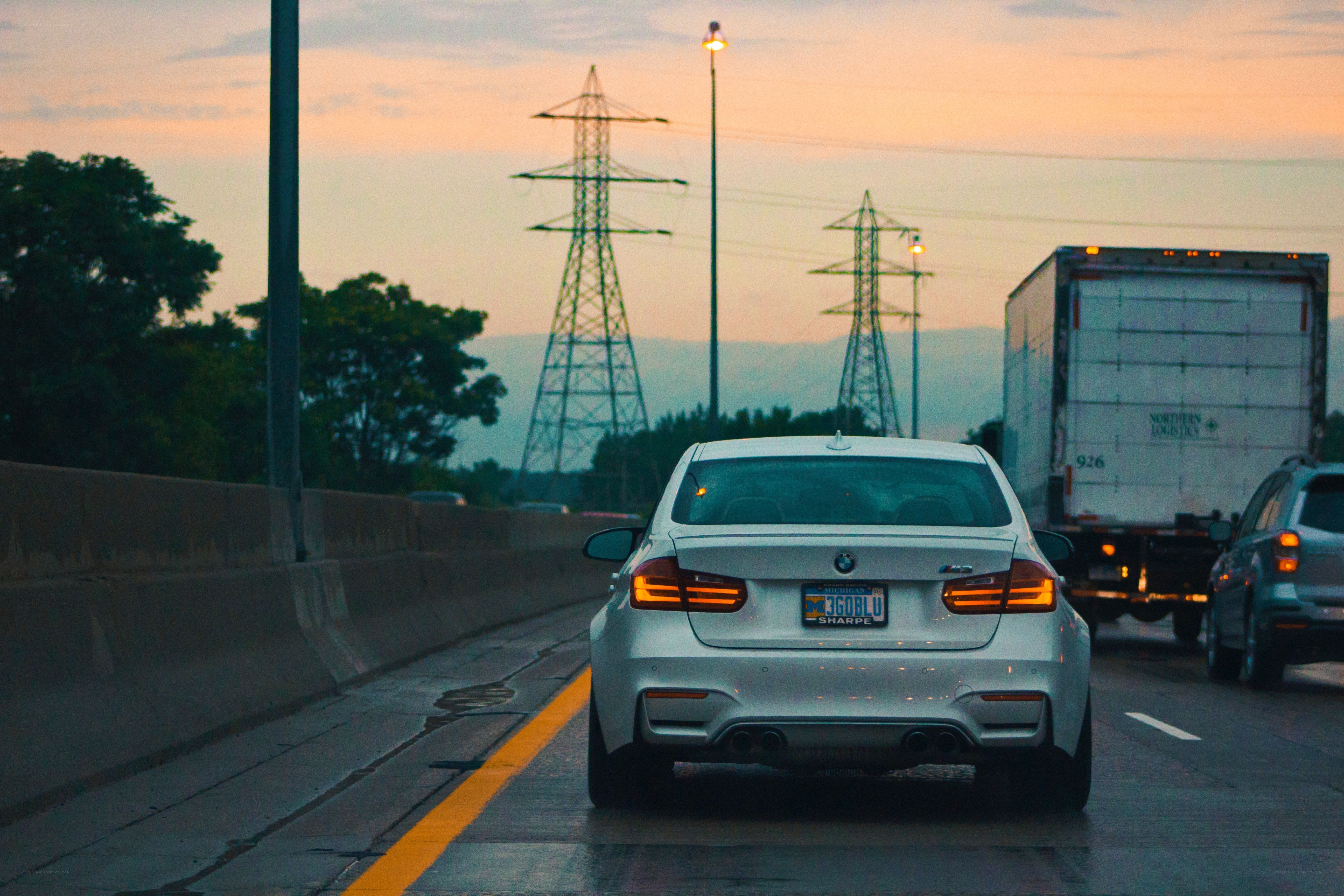 White BMW on highway at dusk