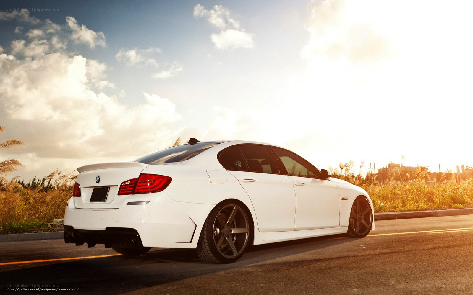 white bmw on road at sunset