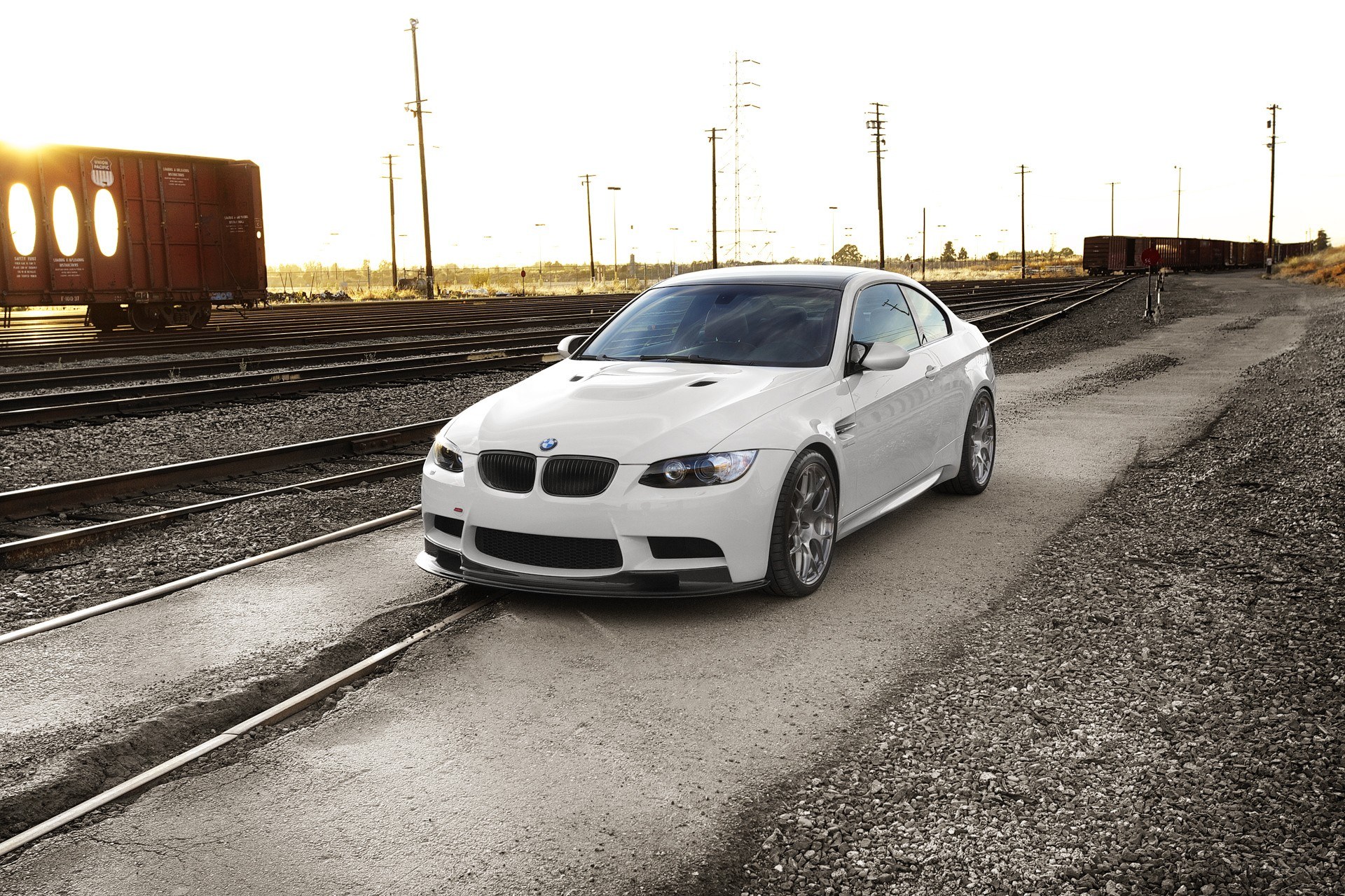 White BMW on train tracks