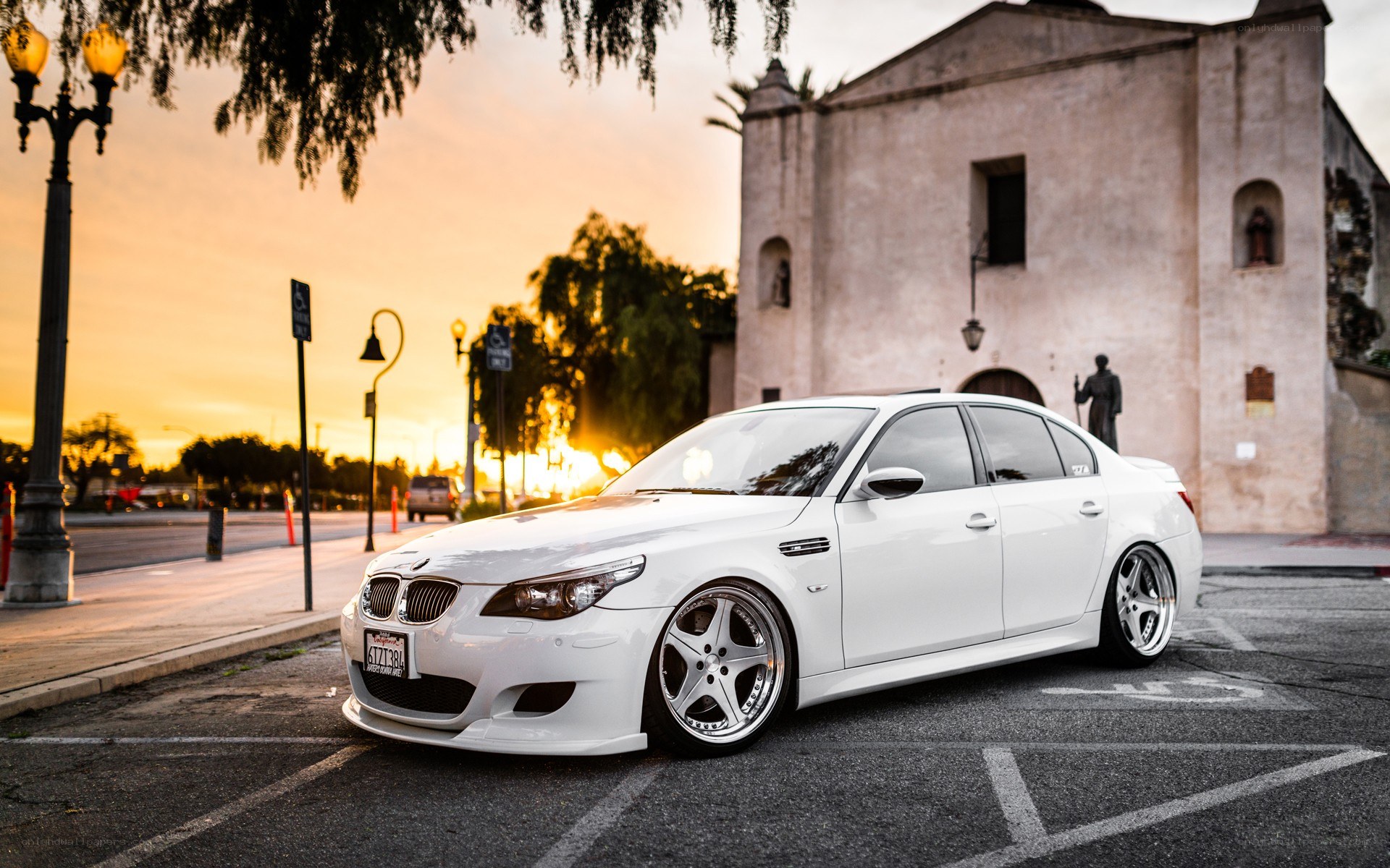 white bmw parked at sunset