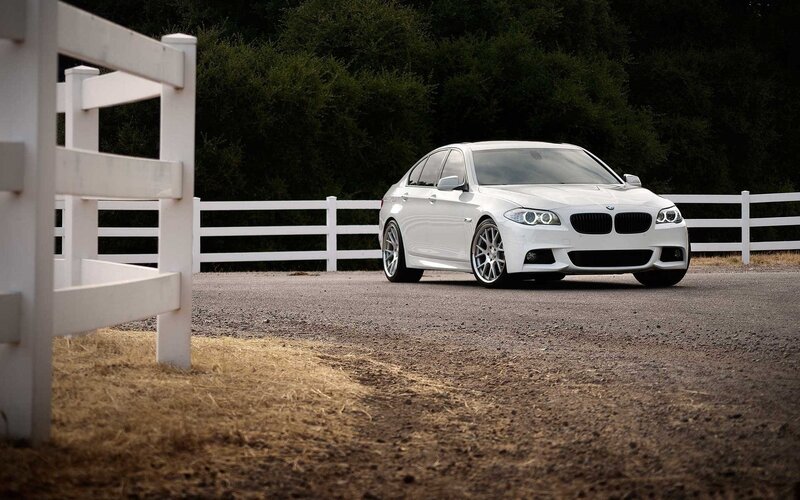White BMW parked by fence