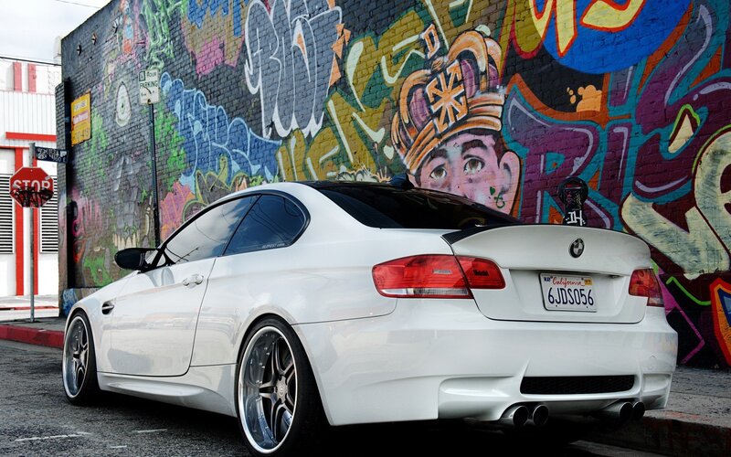 White BMW parked by graffiti wall