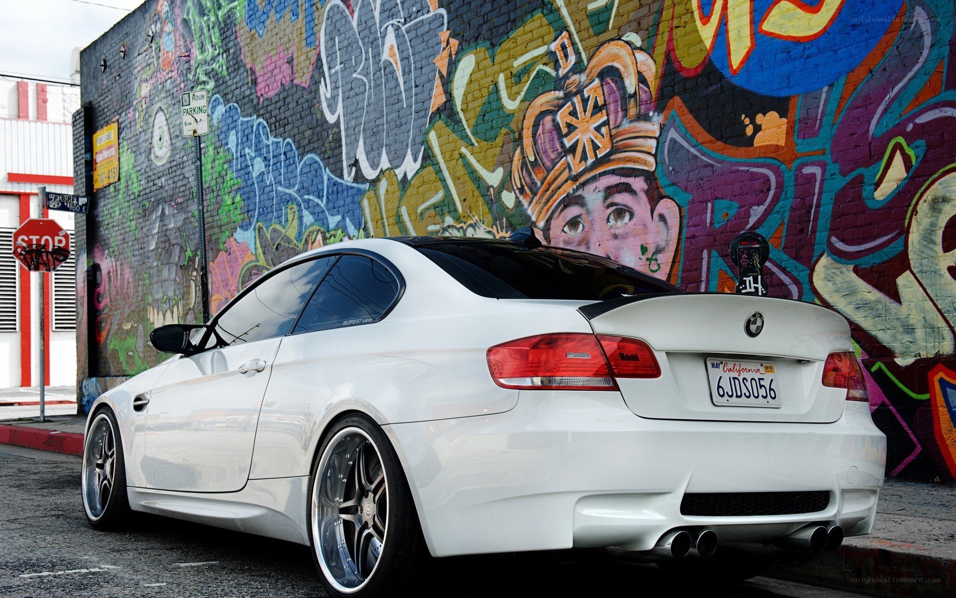 White BMW parked by graffiti wall