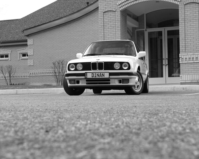 White BMW parked in front of building