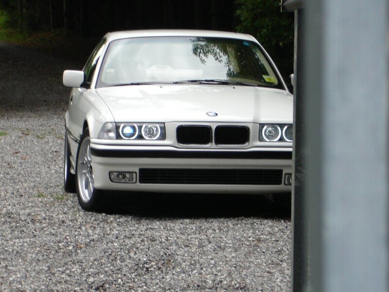 white bmw parked on gravel