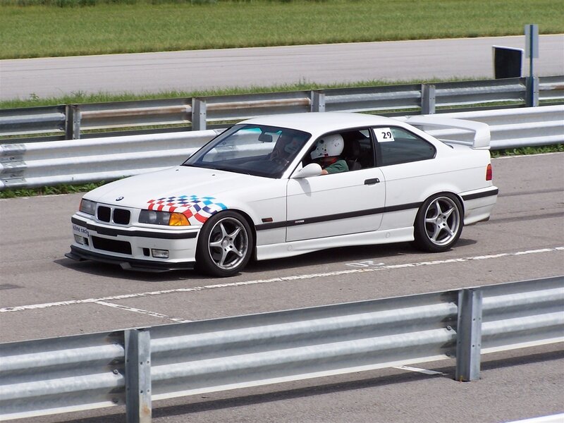 White BMW race car on track