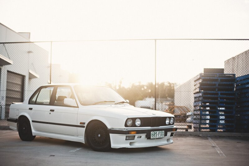White BMW Sedan — Dramatic, Sunset, Photograph, Fence, Pallets