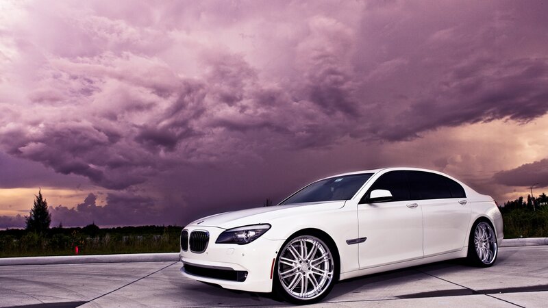 White BMW sedan under purple sky