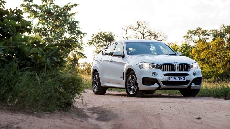 White BMW X6 on a dirt road