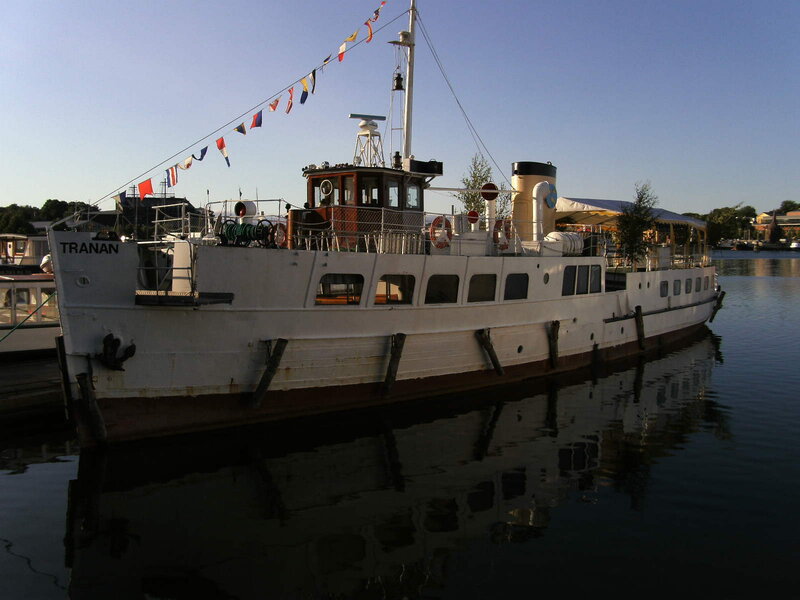 White boat named Tranan docked at harbor