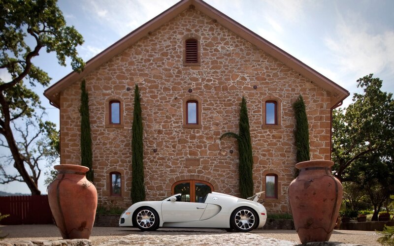 White Bugatti in front of stone house
