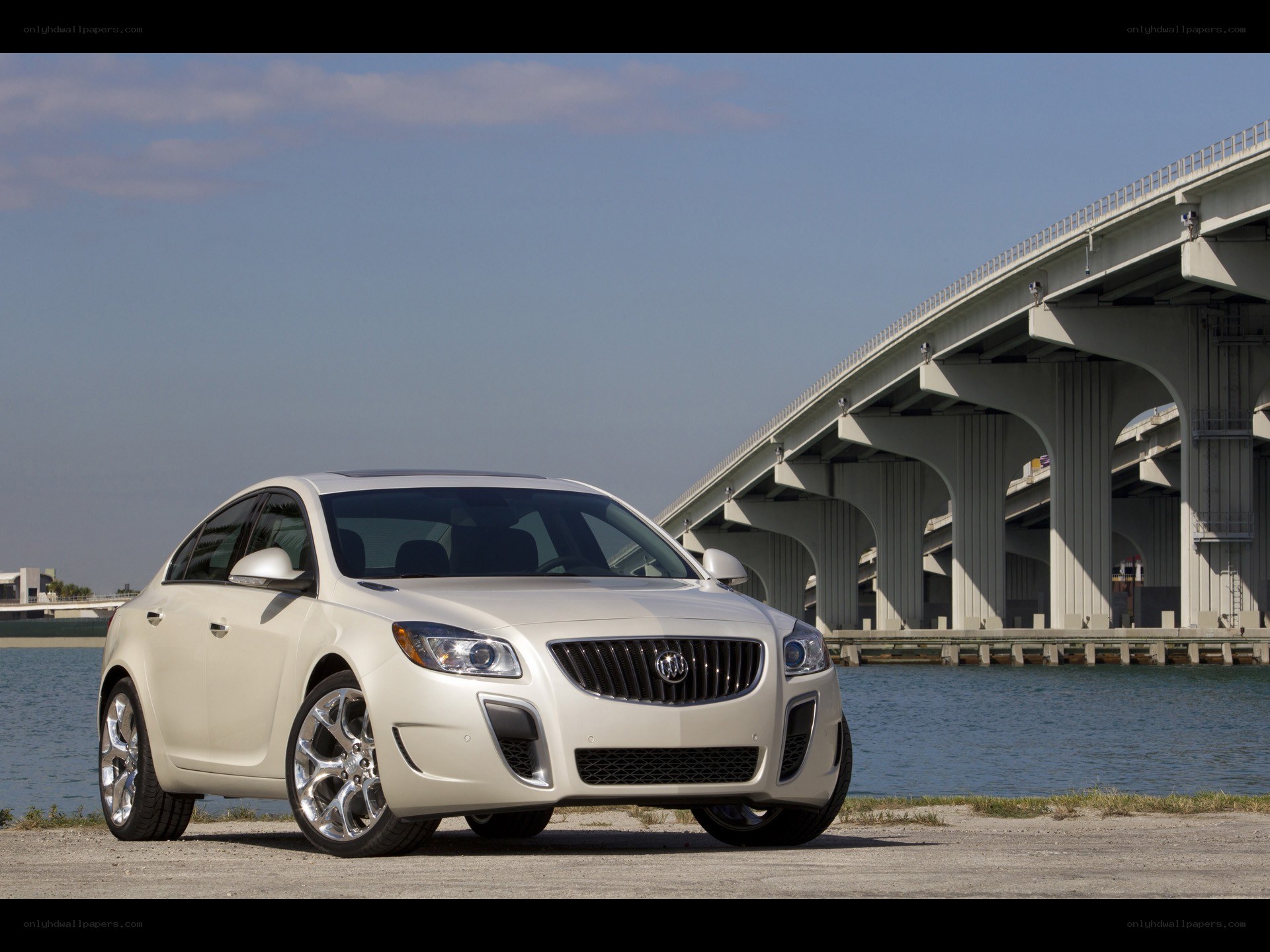 White Buick sedan by a bridge
