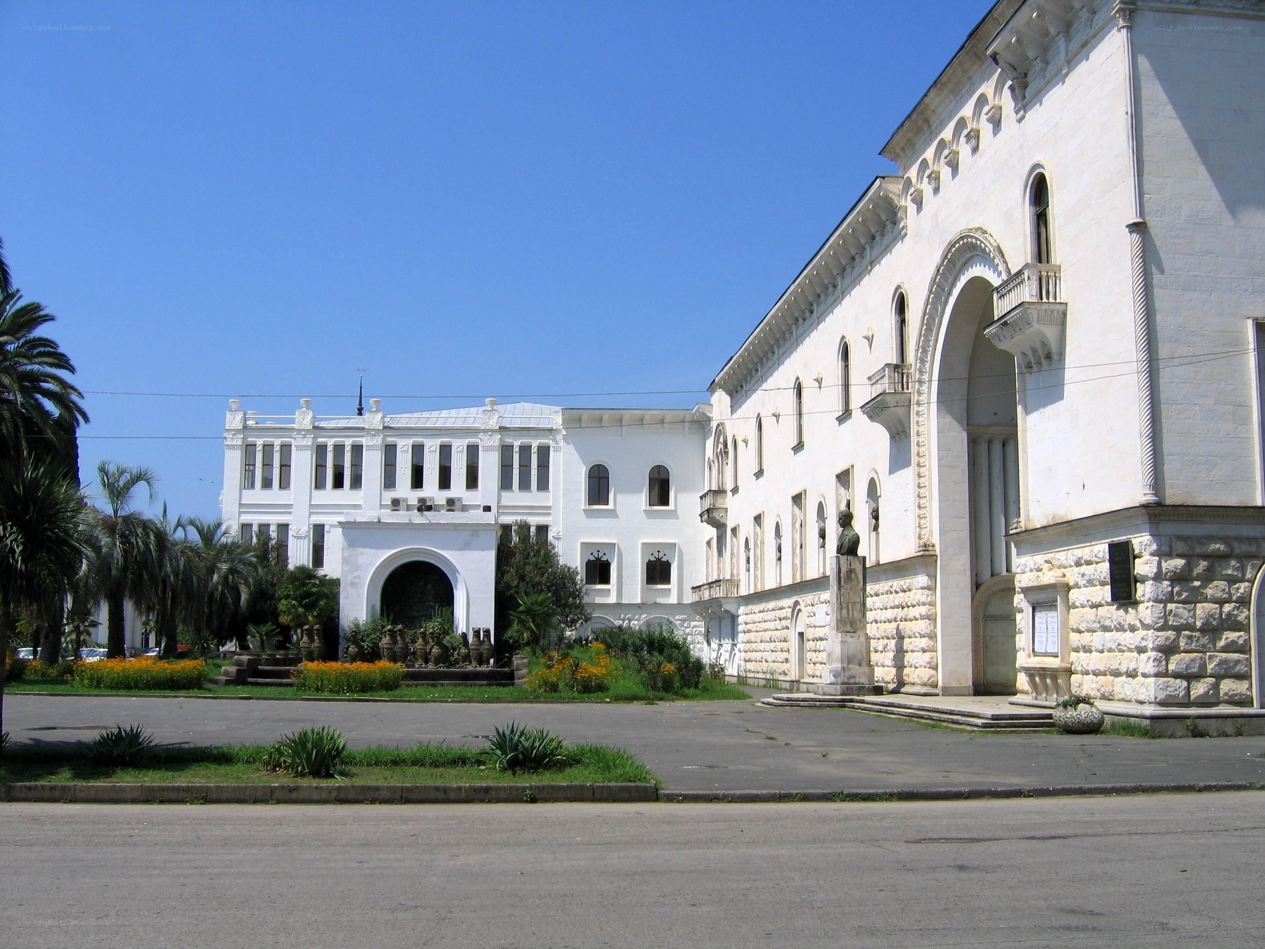 White building with arches and palm trees