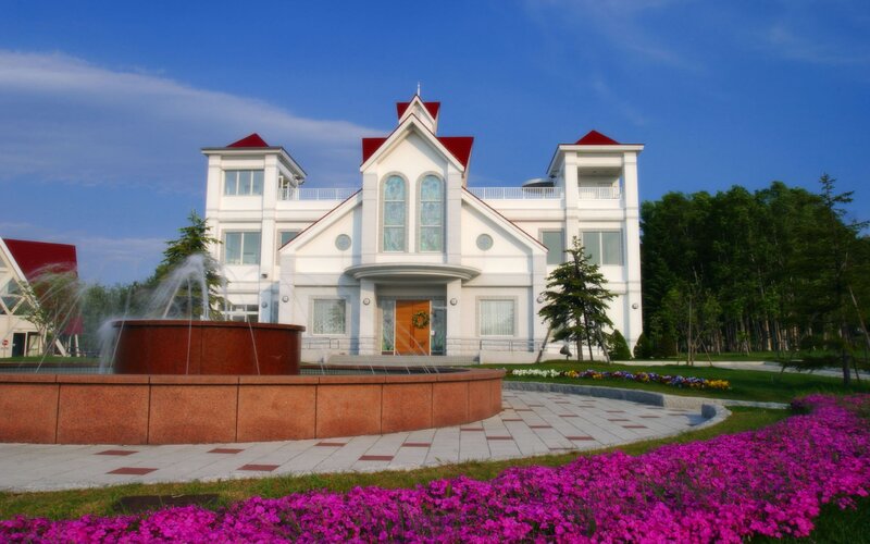 White building with fountain and flowers