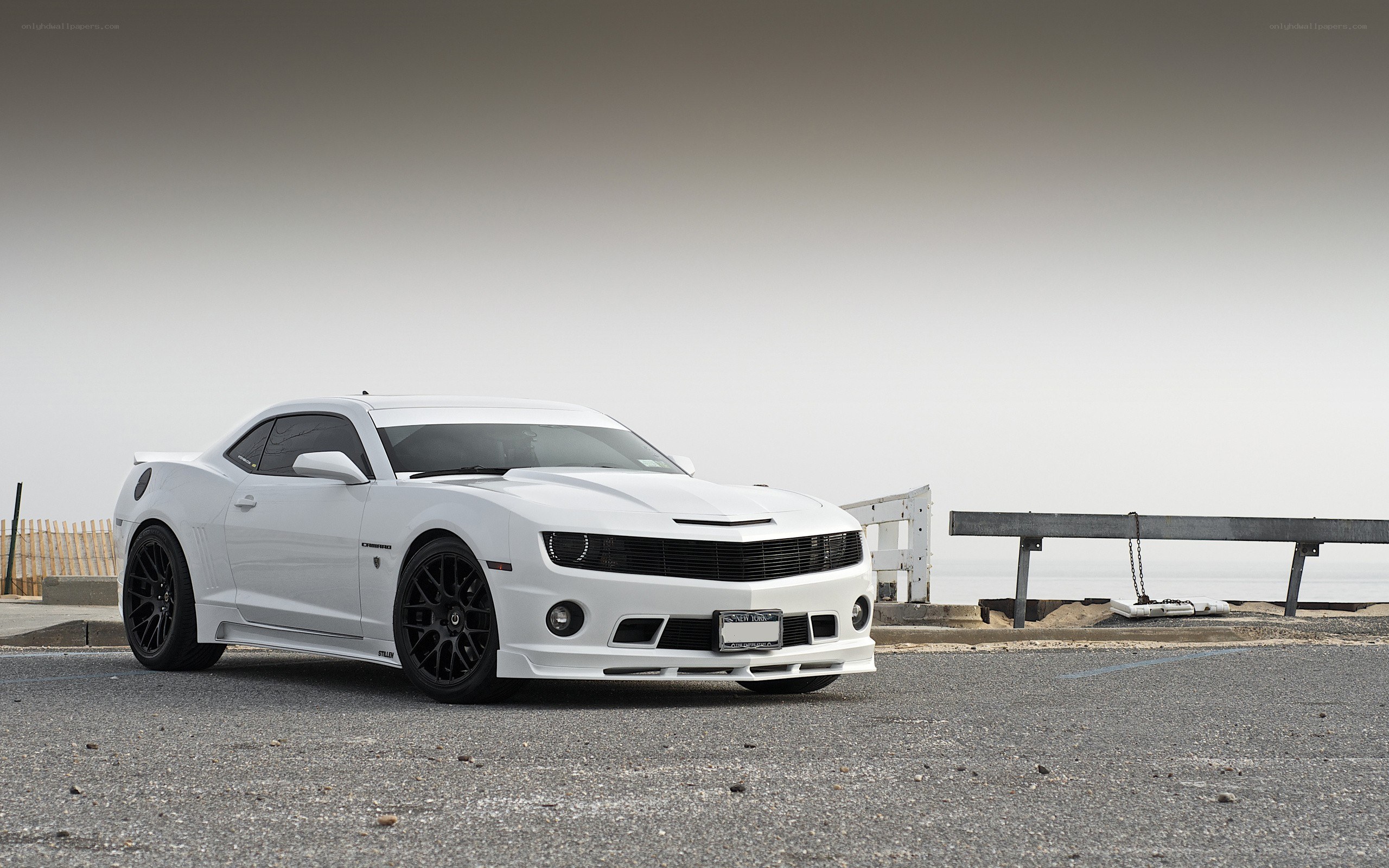 white camaro on coastal road