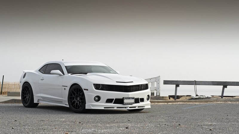 white camaro on coastal road