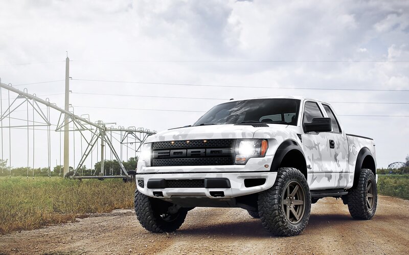 white camo pickup truck on dirt road