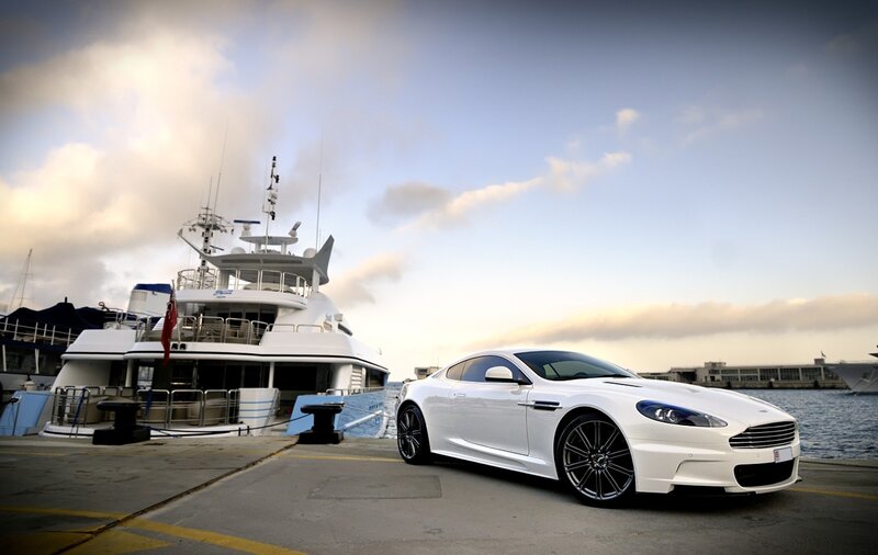 White car and yacht at dock