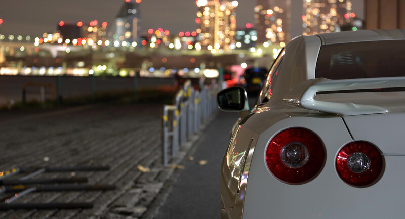 White car at night with city lights