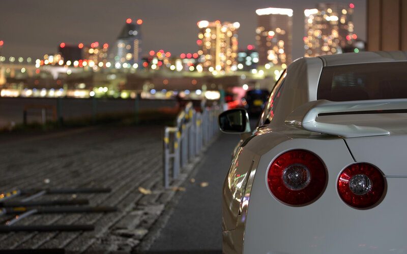 White car at night with city lights