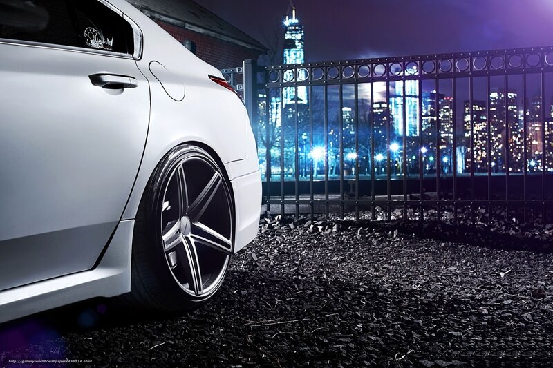 White car at night with city skyline