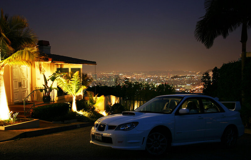 White car at night with city view