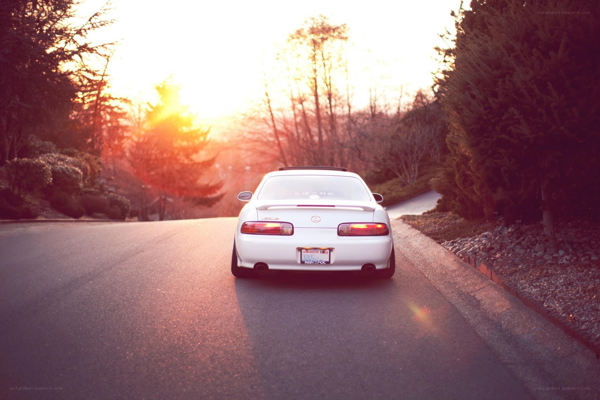 white car at sunset on road