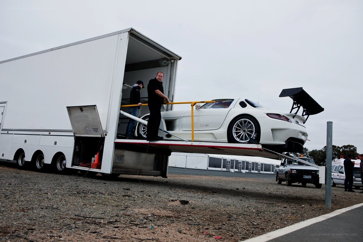 White car being unloaded from trailer