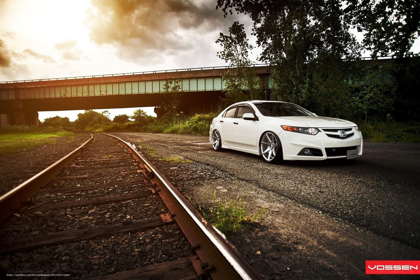 White car by train tracks