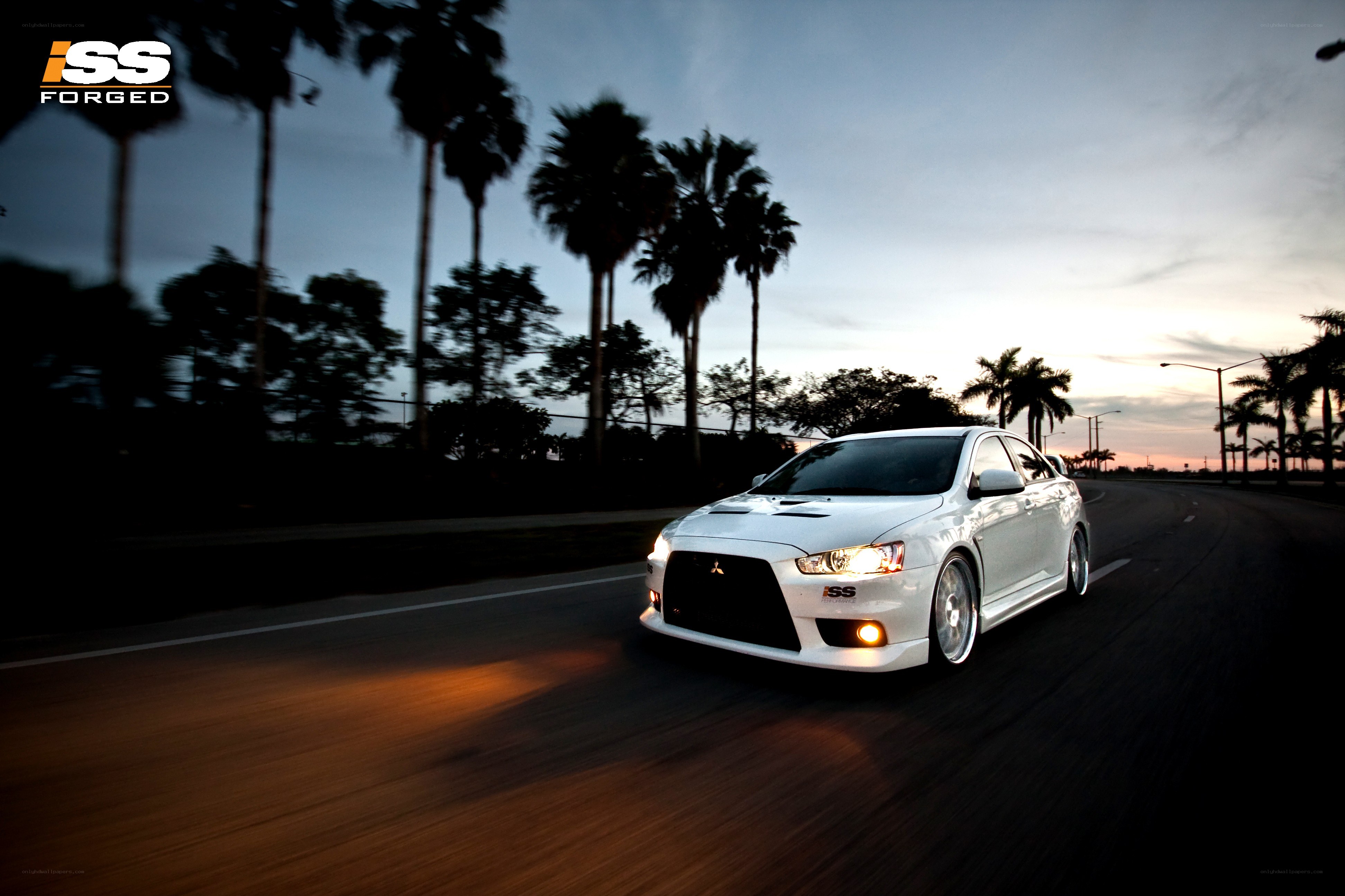 White car driving at dusk