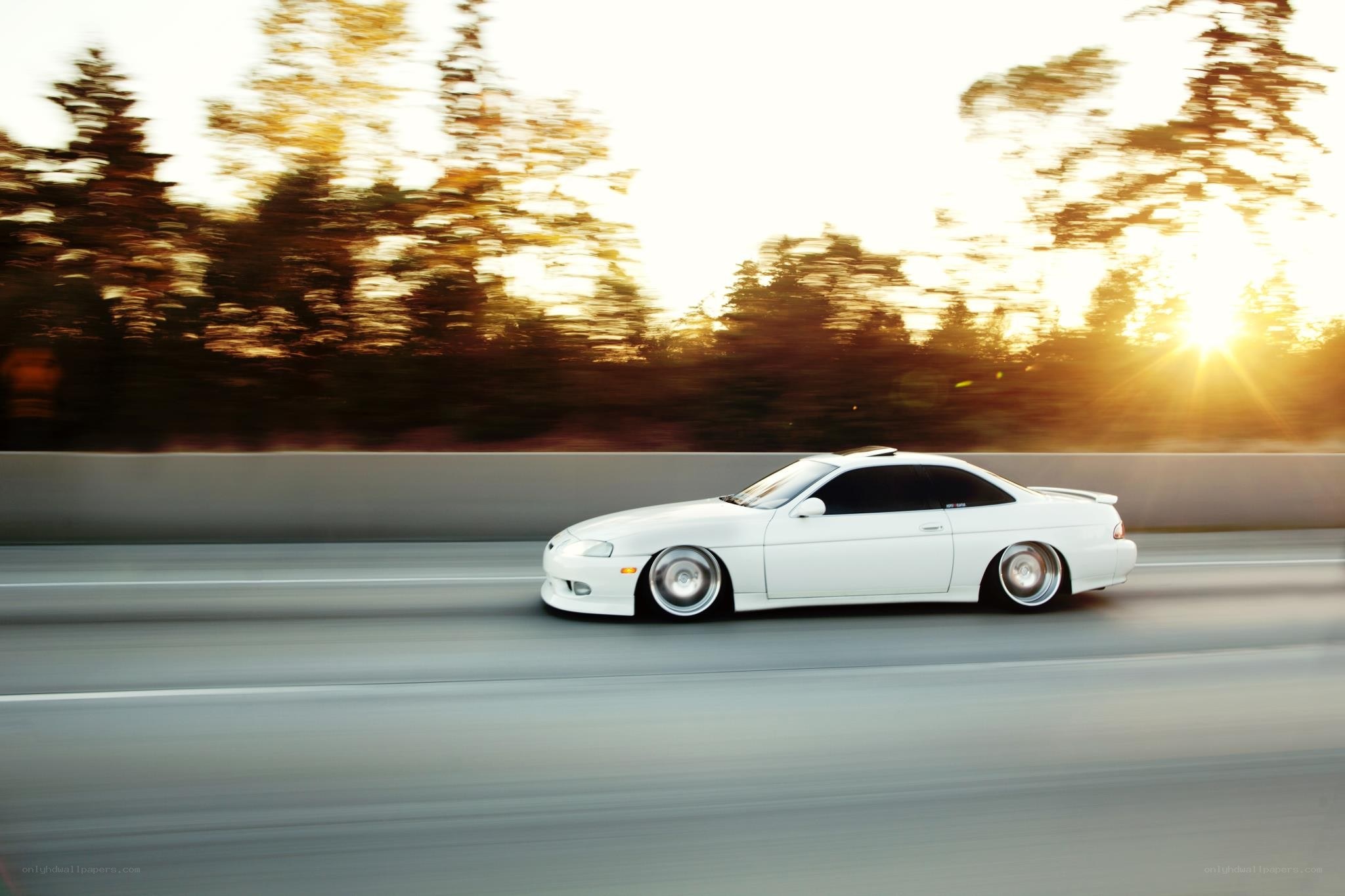 white car driving at sunset