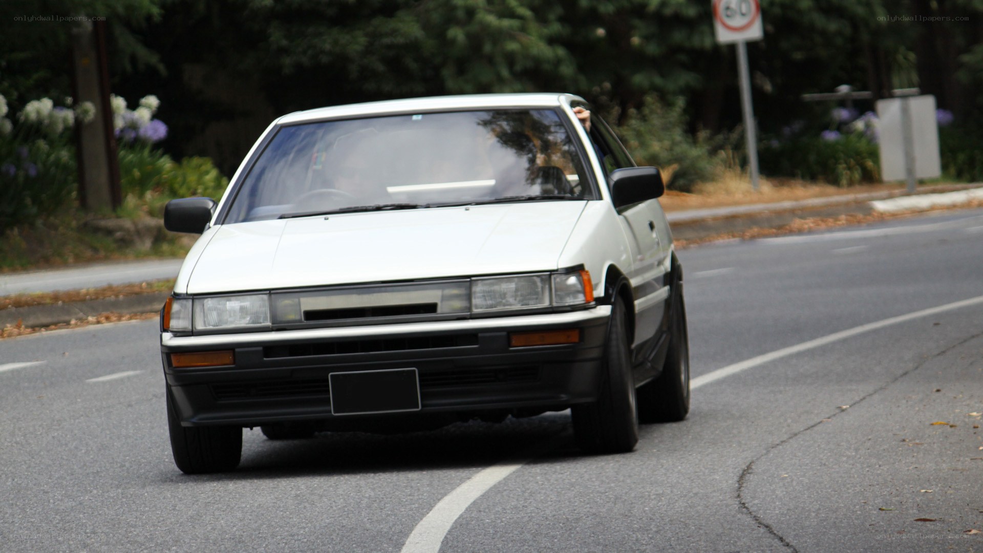 white car driving on road