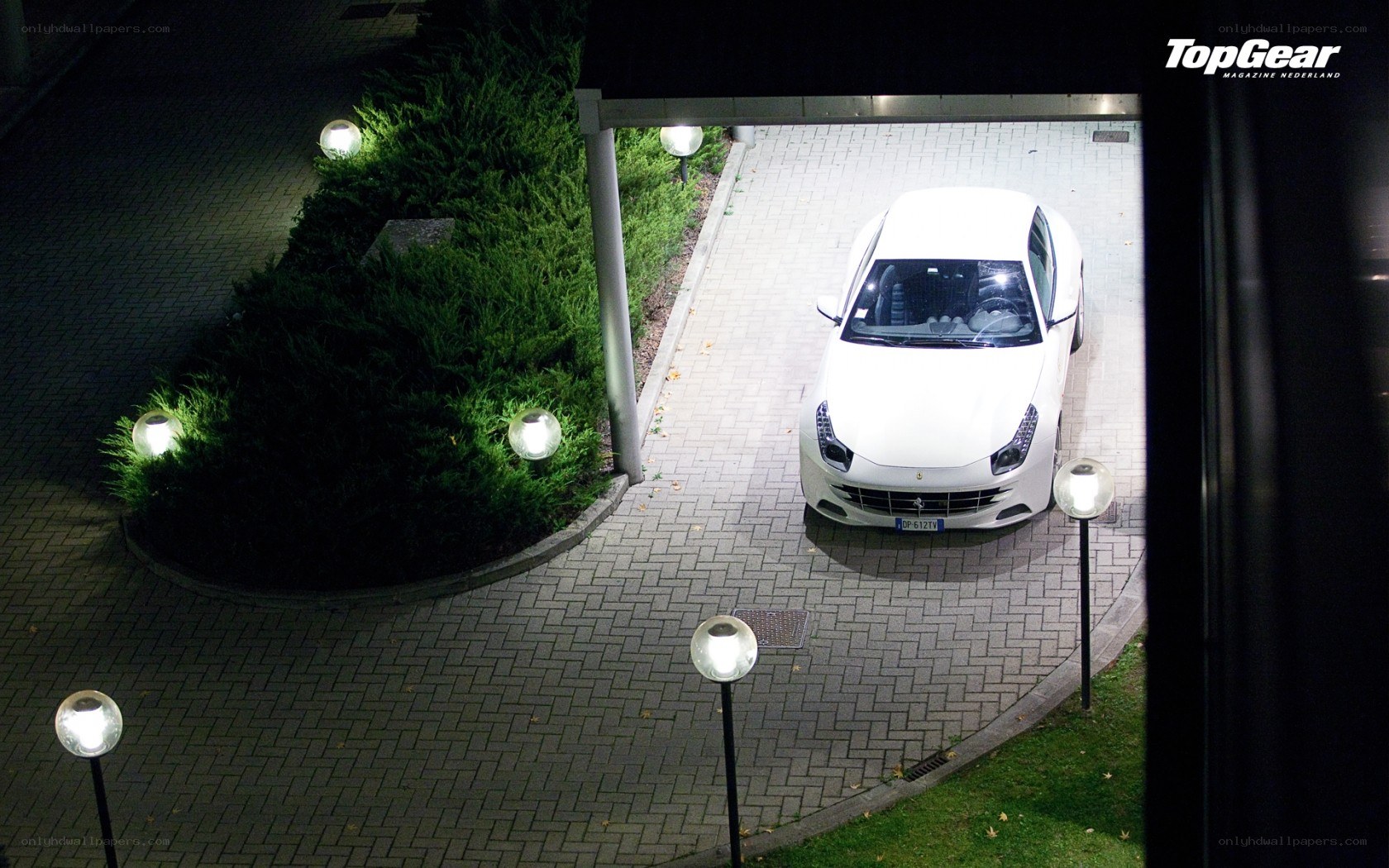 White car in driveway at night