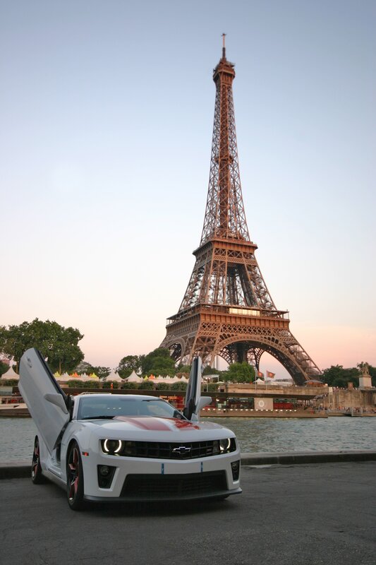 White car in front of Eiffel Tower