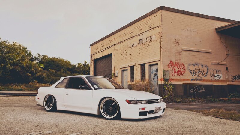 white car in front of graffiti building