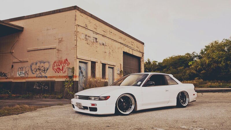 white car in front of graffiti building