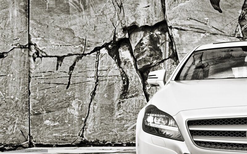 White car in front of rock wall