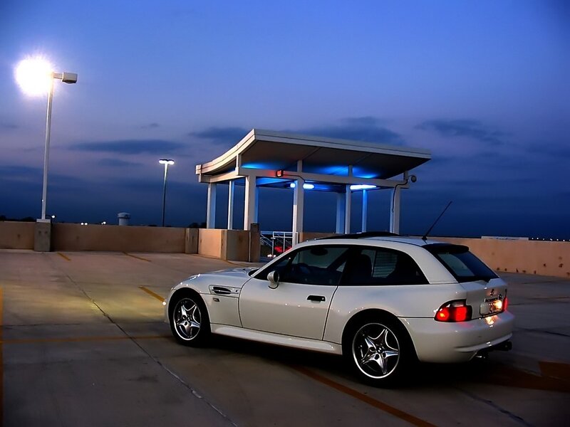 White car in parking garage at dusk