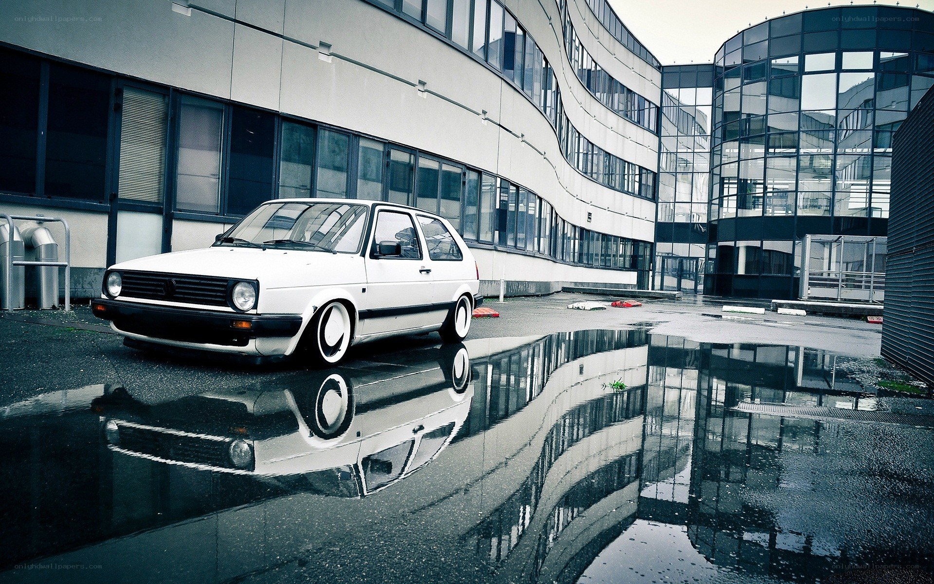 White car in wet courtyard