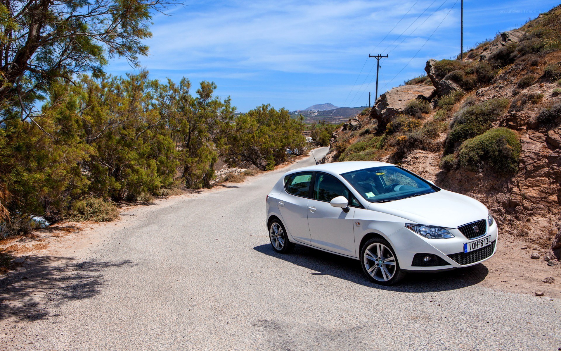 White car on a coastal road