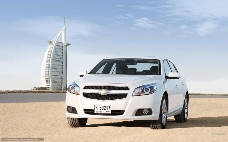 White car on beach with Burj Al Arab