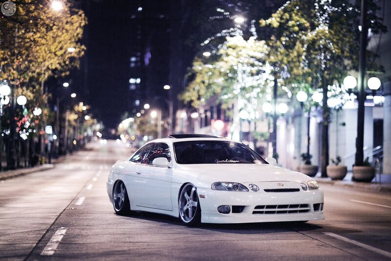 White car on city street at night