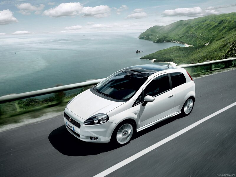 White car on coastal road