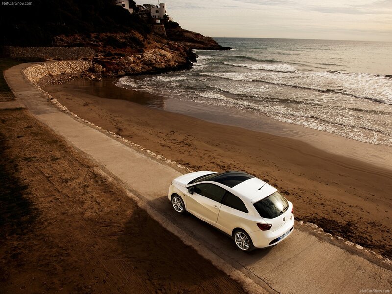 White car on coastal road
