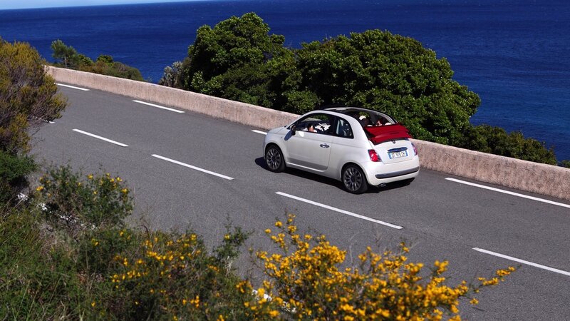 White car on coastal road