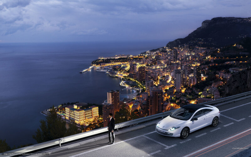 White car on coastal road at night
