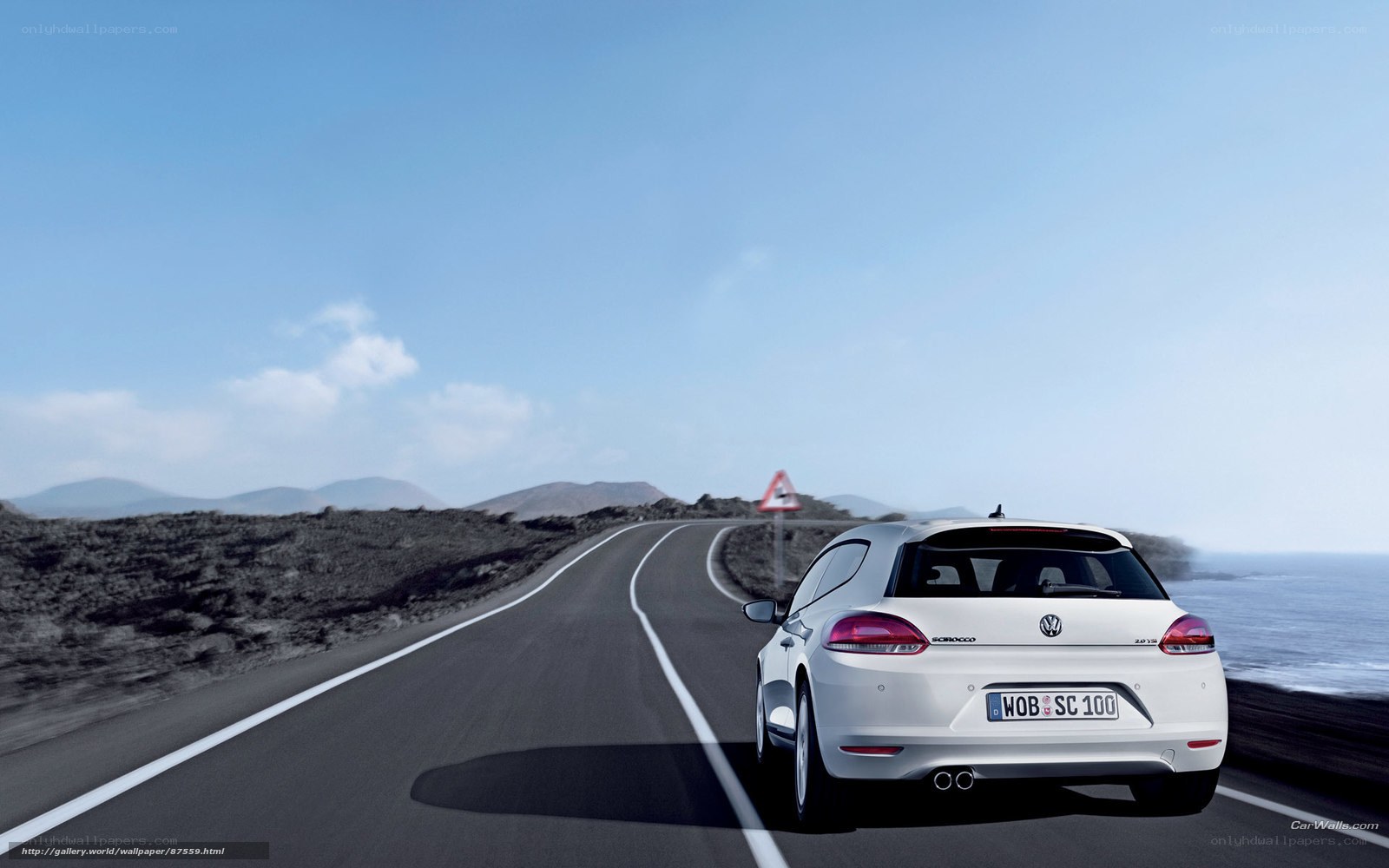 White car on coastal road