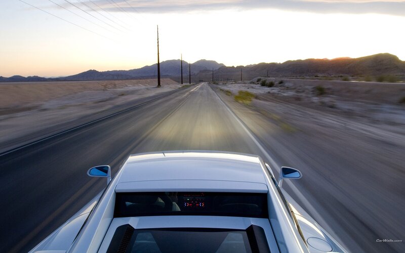 White car on desert road