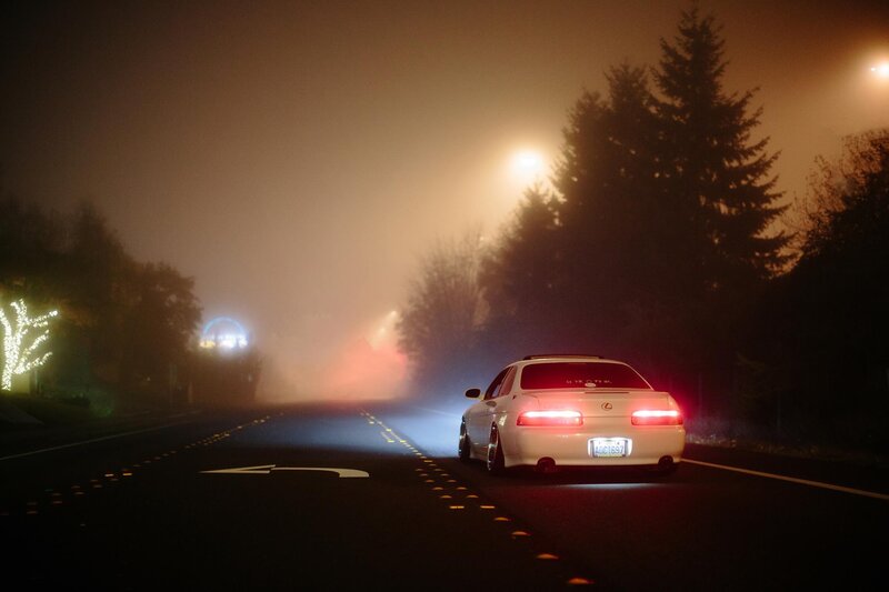 White car on foggy road at night