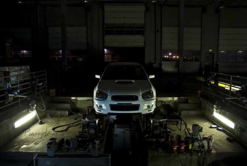 White car on lift in garage